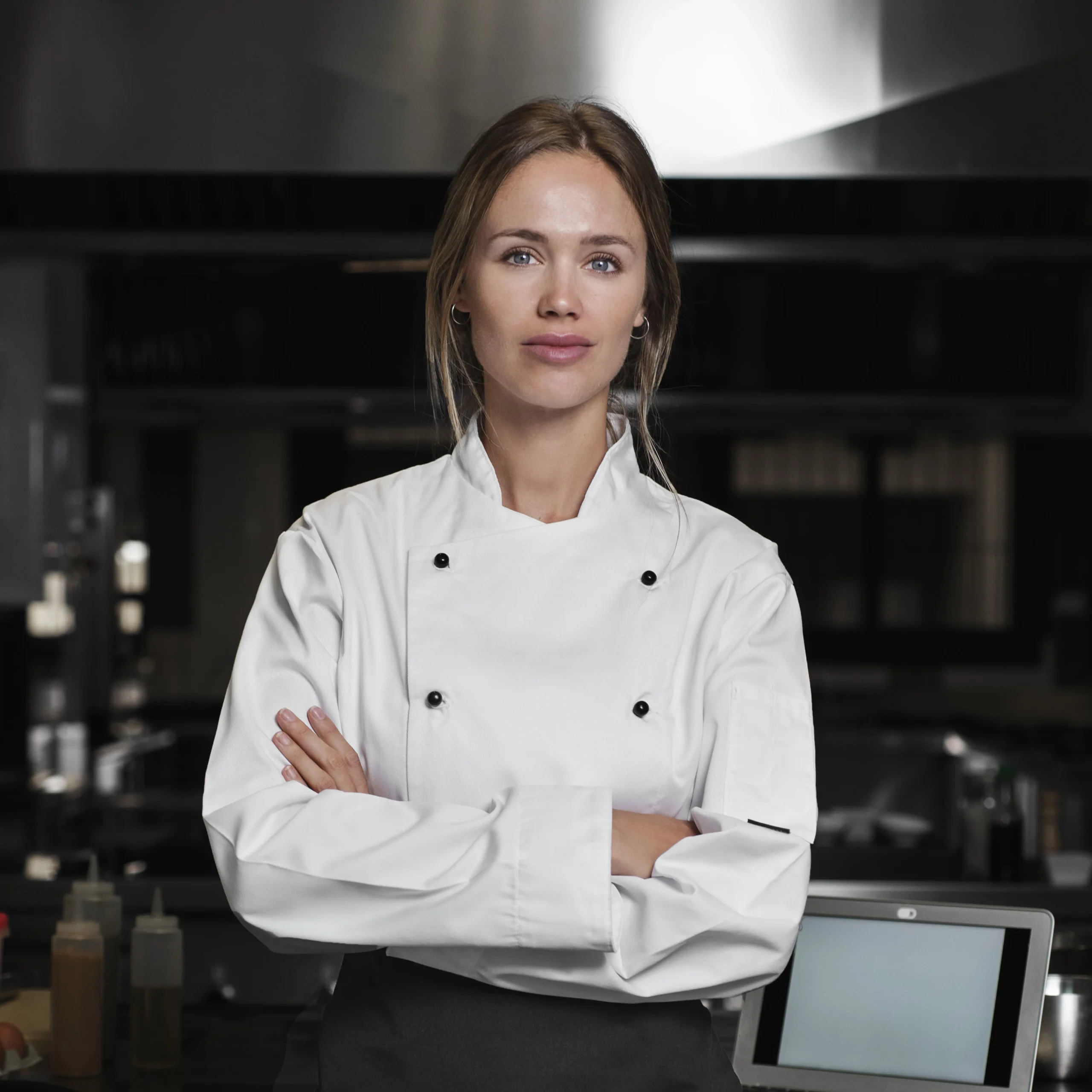 Chef saly wearing a white apron and standing in the kitchen