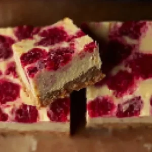Healthy high protein raspberry cheesecake bars with a delicious creamy topping