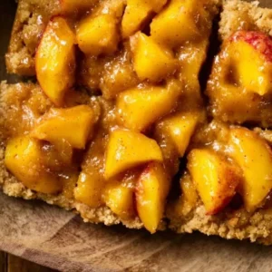Peaches and cream crumble bars with a golden crumble topping.